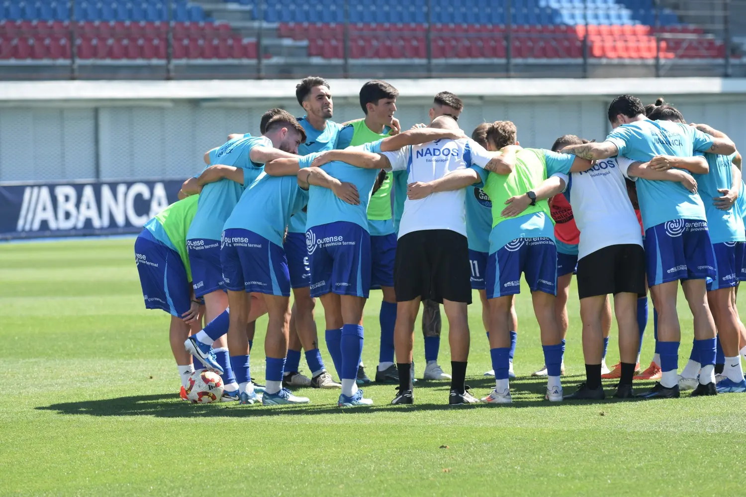 Jugadores del Ourense CF reunidos sobre el césped de O Couto