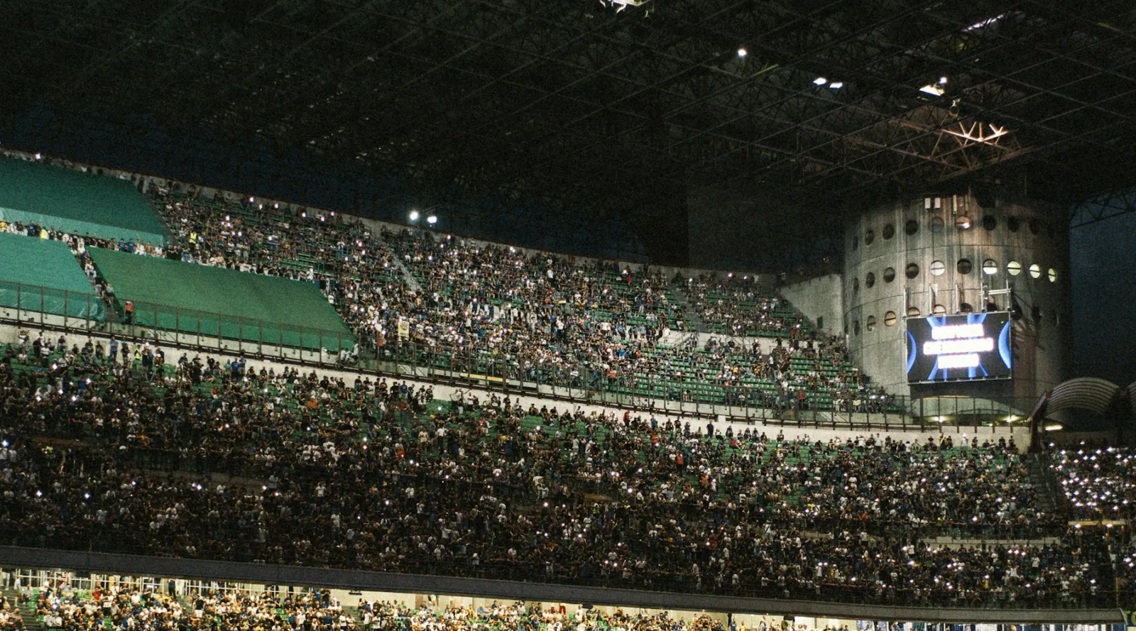 Gradas llenas durante un partido nocturno de fútbol