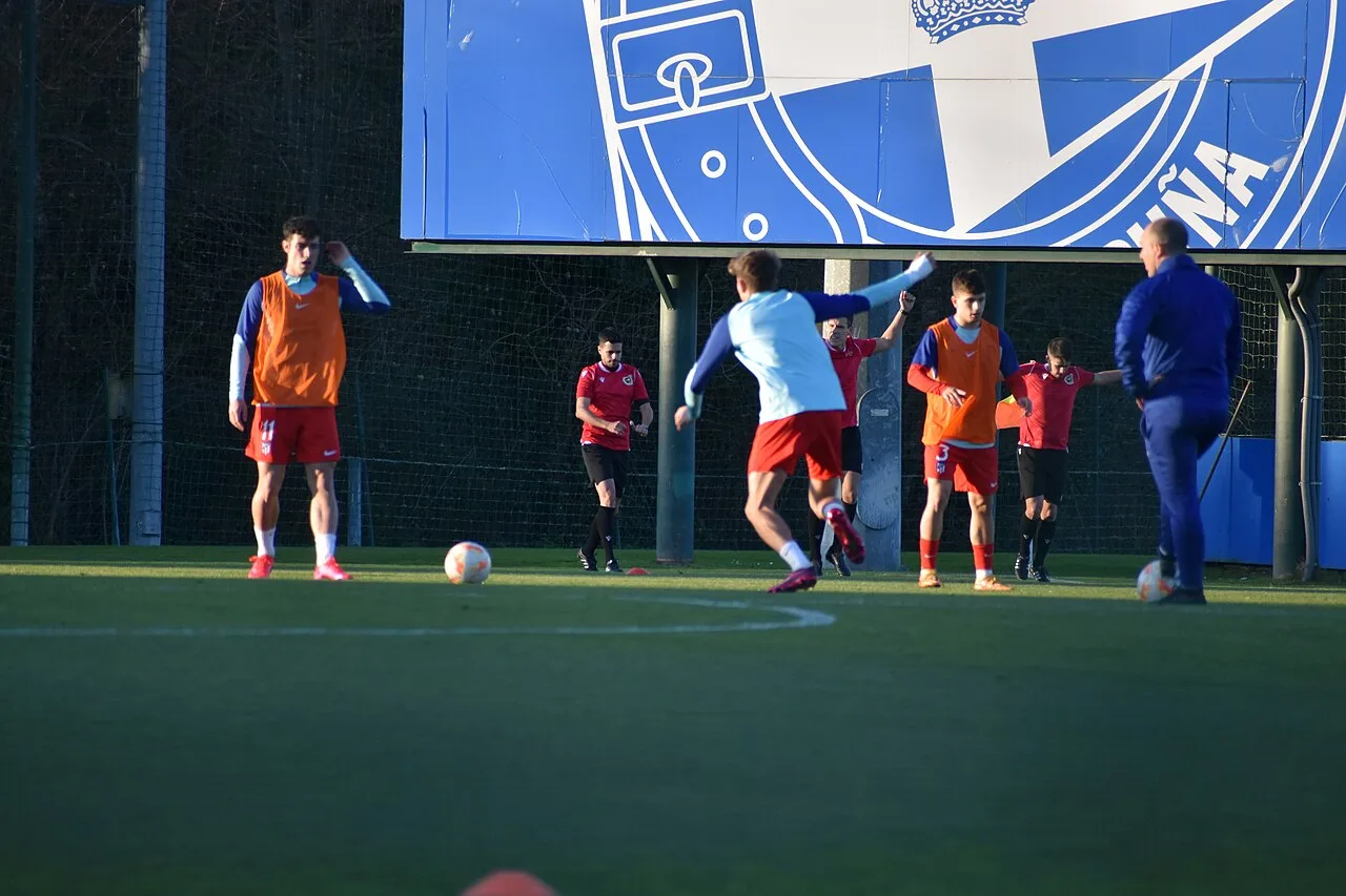 Un futbolista juvenil del Deportivo conduce el balón en un partido disputado en Abegondo