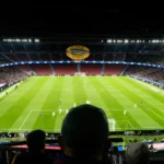 Estadio de fútbol iluminado durante un partido nocturno