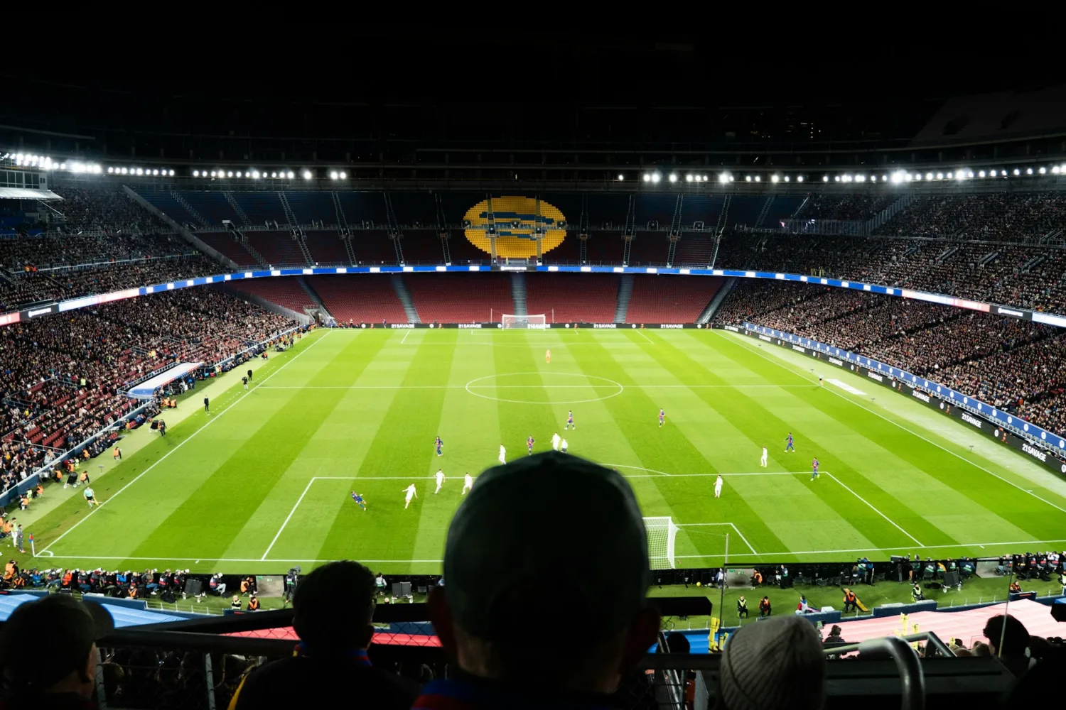 Estadio de fútbol iluminado durante un partido nocturno