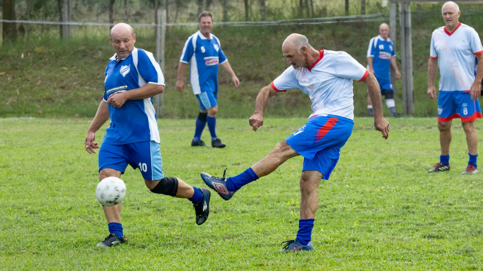 Futbolistas disputando un partido sobre césped