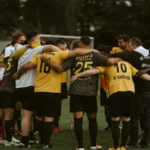 Jugadoras de fútbol reunidas en círculo sobre el césped