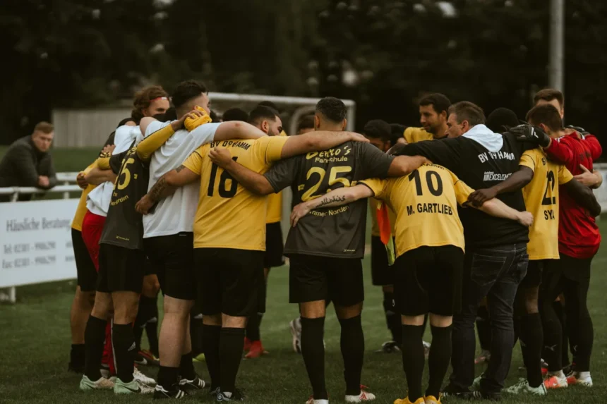 Jugadoras de fútbol reunidas en círculo sobre el césped